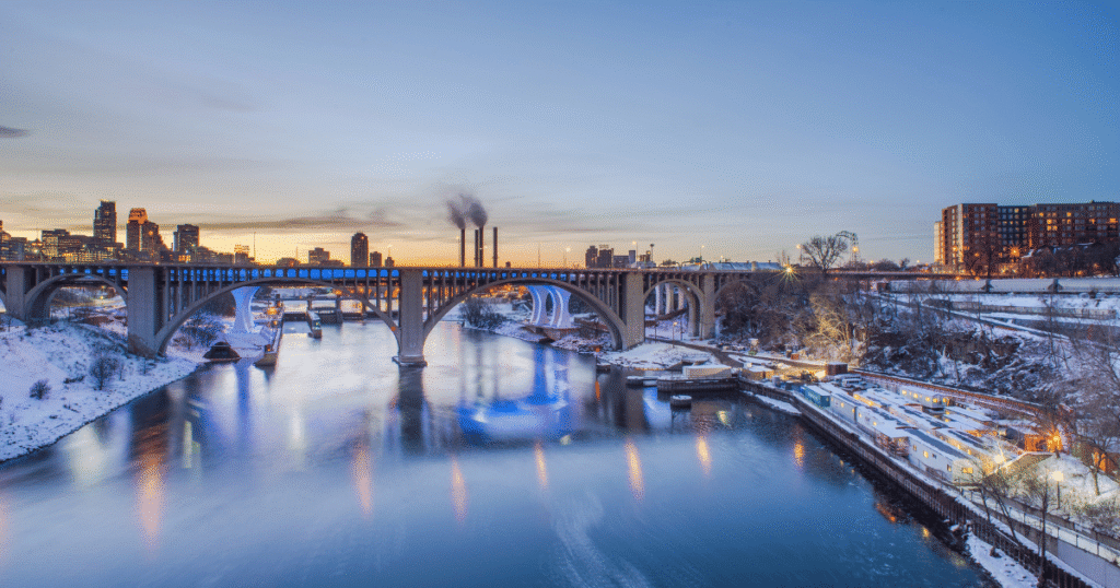 Minneapolis skyline in winter with snow and Mississippi River at sunset