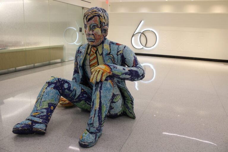 Seated mosaic figure sculpture in the skyway-level lobby of 60 South Sixth in Minneapolis