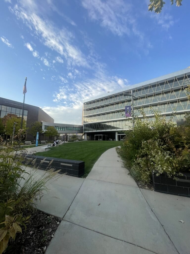 Lawn and walkway leading to a modern glass building on the Minneapolis College campus