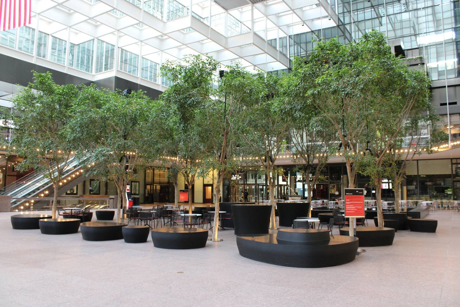 Trees and cafe seating in the IDS Center Crystal Court atrium on the Minneapolis skyway