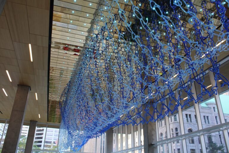 Blue glass and LED sculpture Current Conditions hanging in the Minneapolis Public Service Building lobby